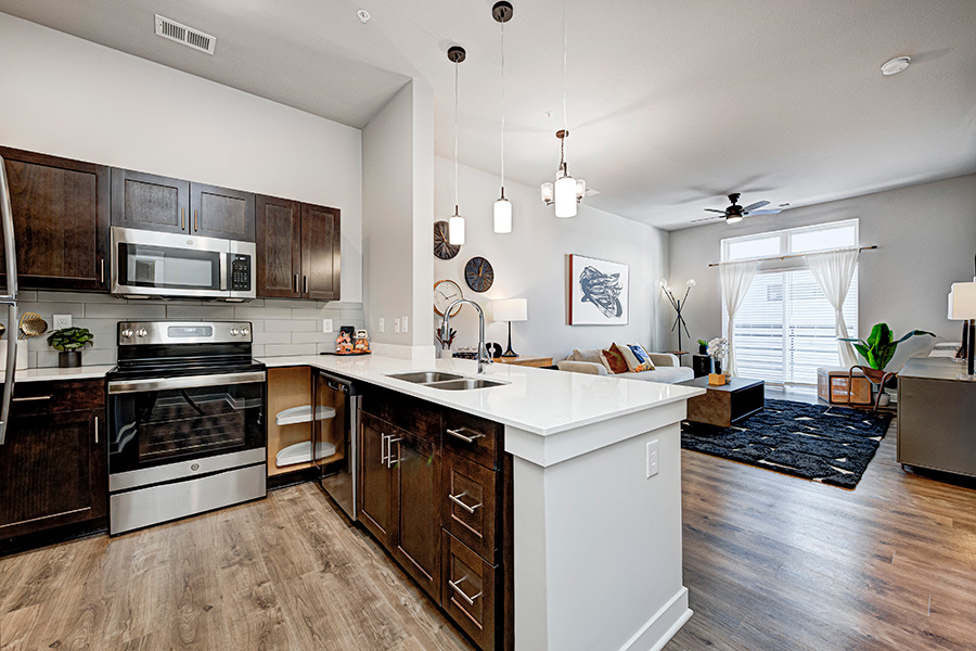 If you live in a building with several apartments like at Continuum Apartments, respect your neighbors and keep the noise down during parties. An open-concept kitchen and living room at Continuum Apartments.