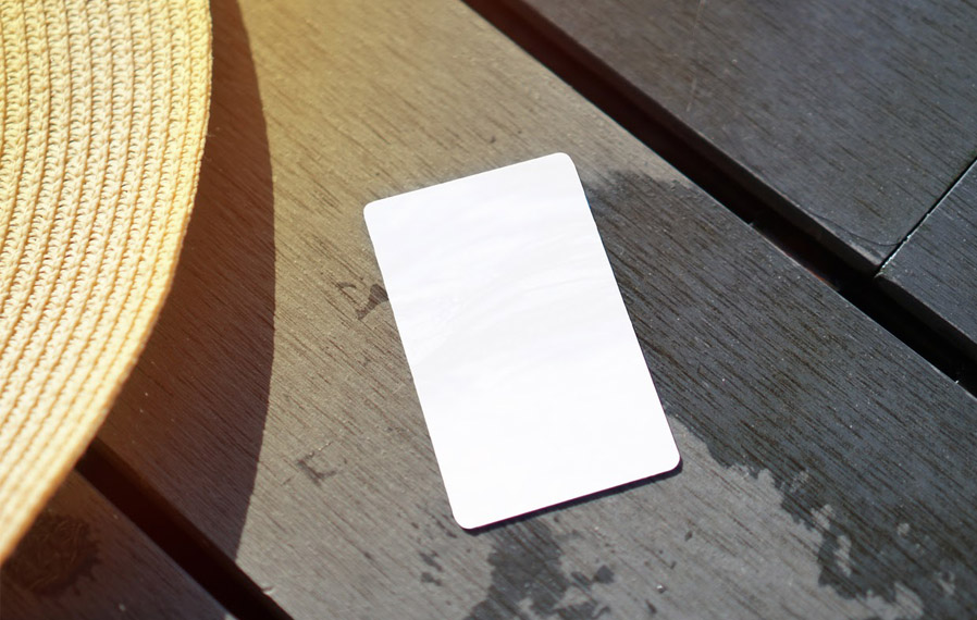Don't forget your pool pass to to take a refreshing swim at Block 20. Summer hat and key card on a deck floor.